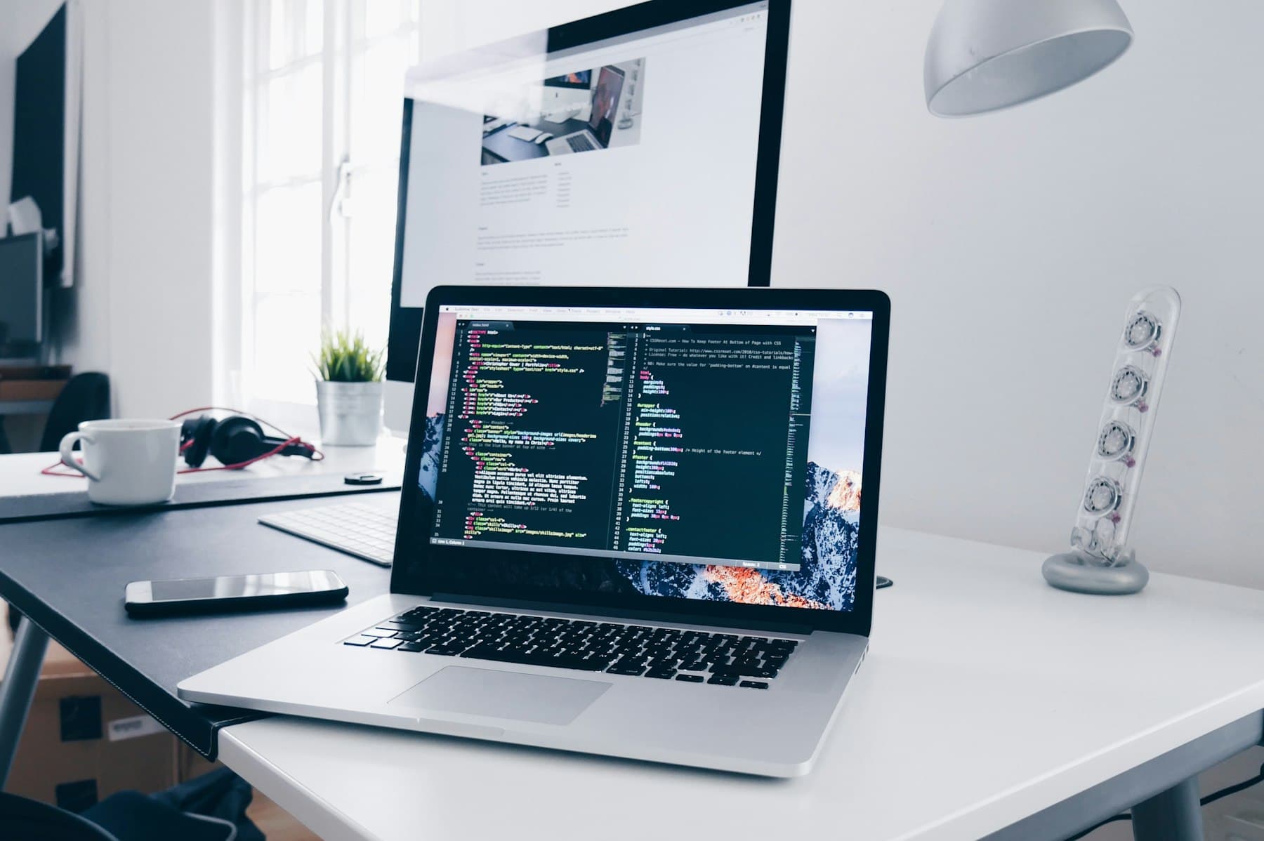 A laptop with code open on a bright white desk