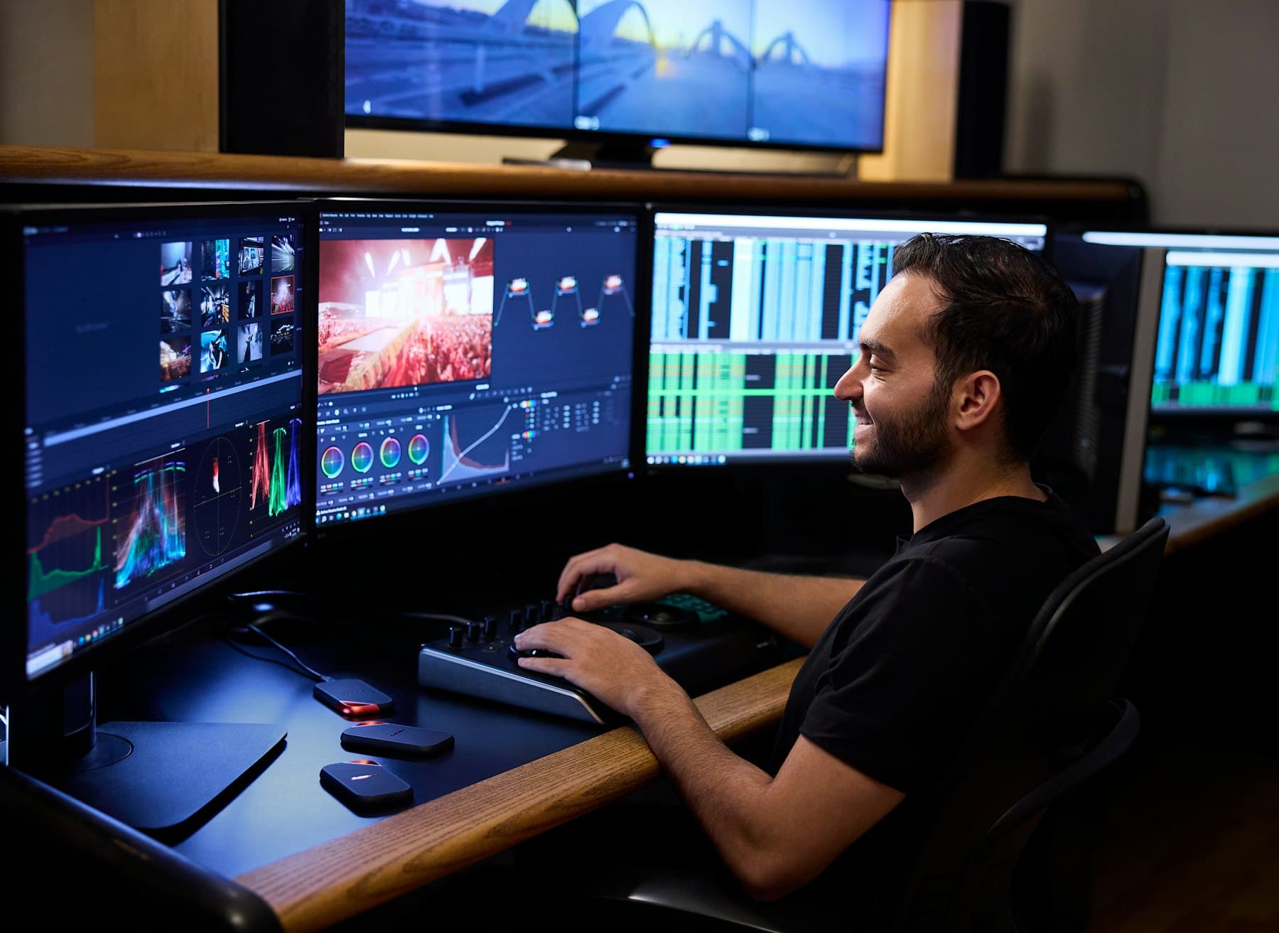 A man at a desk with several monitors