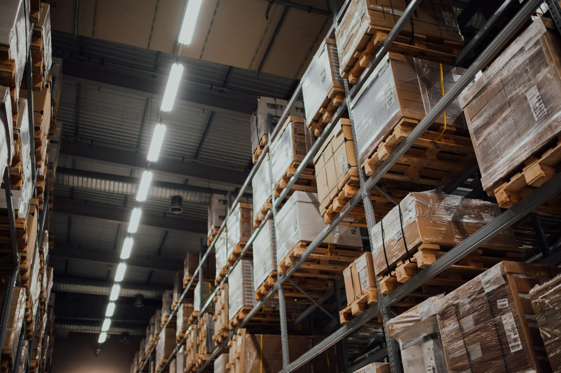 Cardboard boxes stacked on tall metal shelves in a stockroom